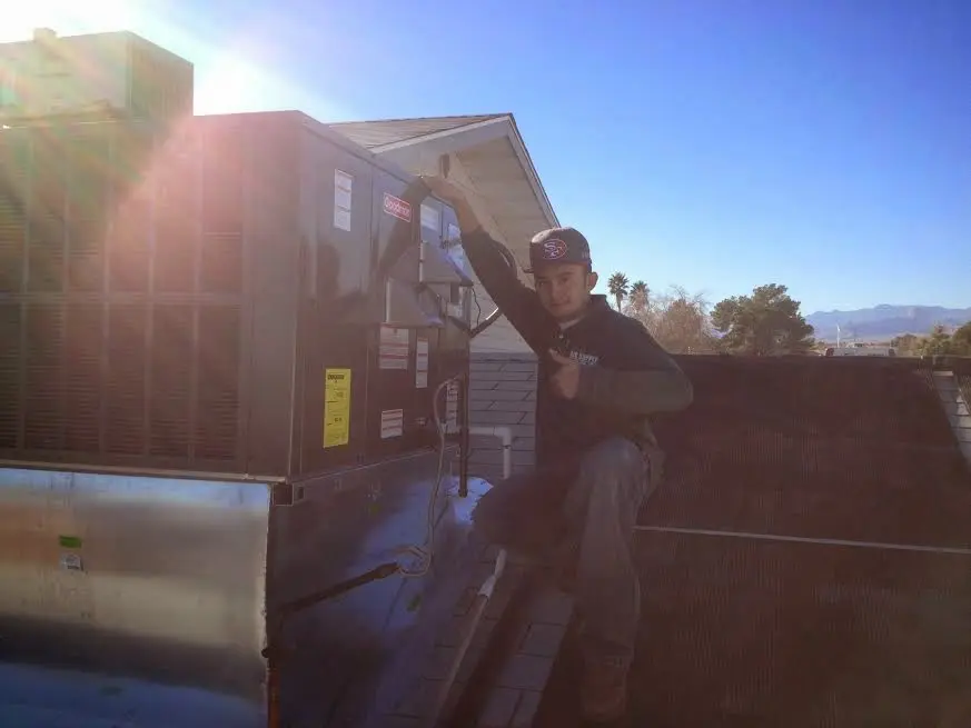 HVAC technician performing Air Duct Repair on a rooftop unit in Ellicott City